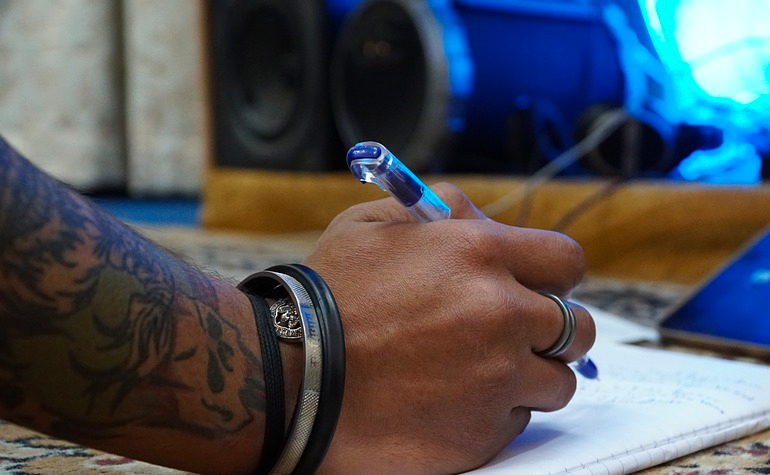 photo of tattoo hand writing songs